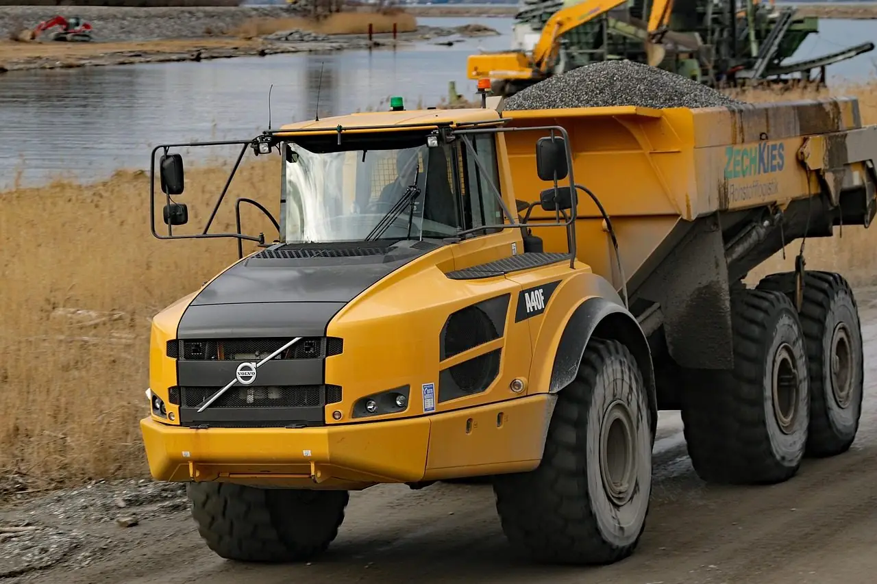 Yellow articulated dump truck loaded with gravel